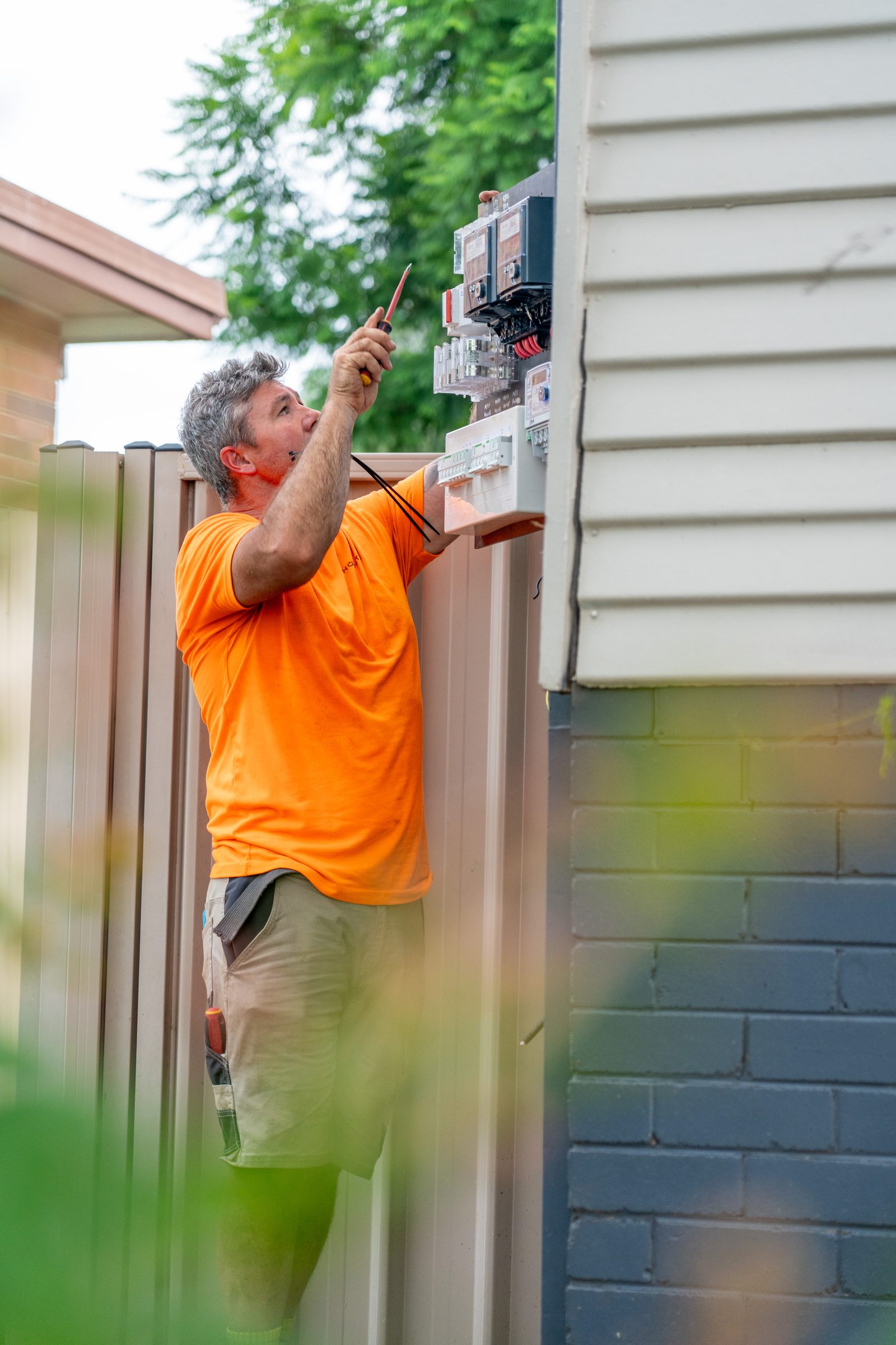 Electrician testing a residential meter box with a test probe