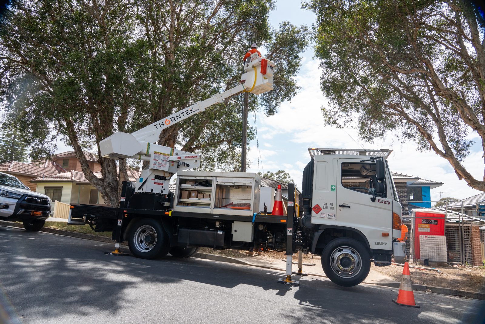 Thorntek elevated work platform truck with boom extended on a suburban street