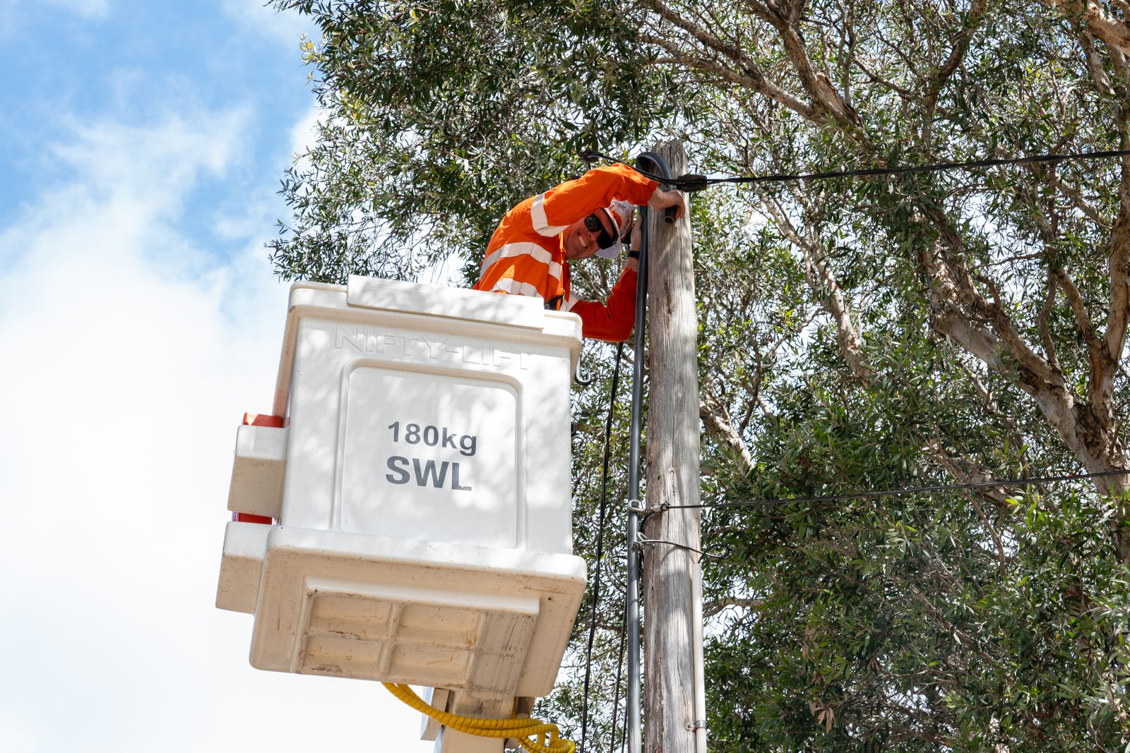 Linesman working from a Thorntek EWP bucket at the top of a private power pole